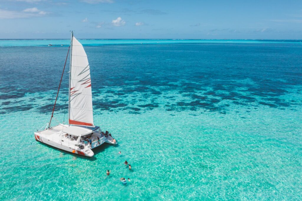 family swimming near a catamaran 