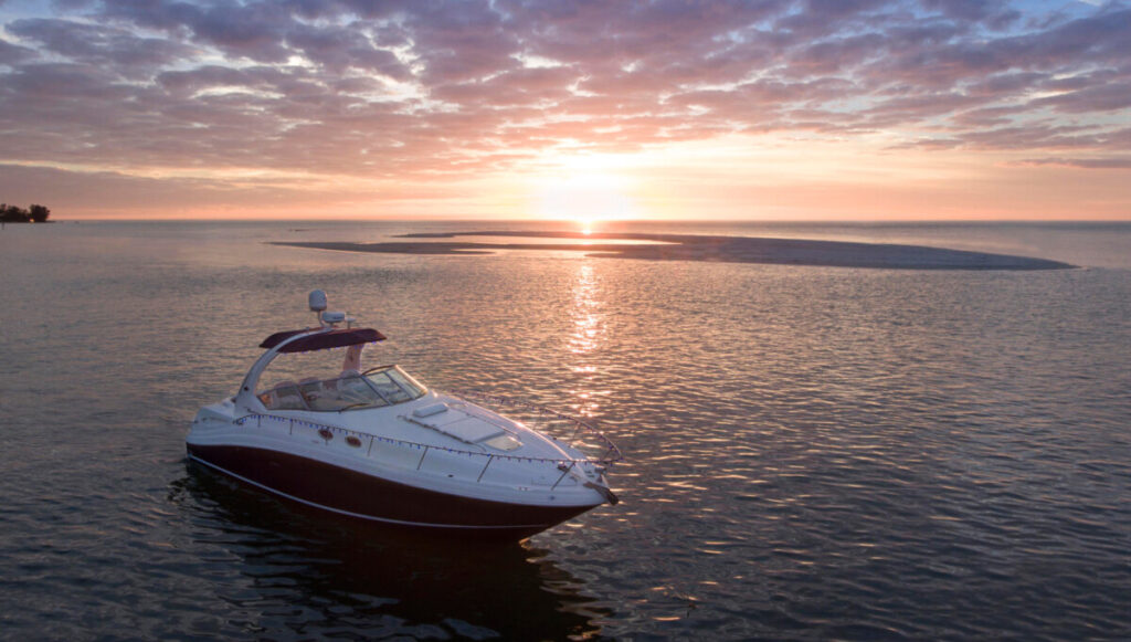 A boat on the ocean with a sunset in the background.