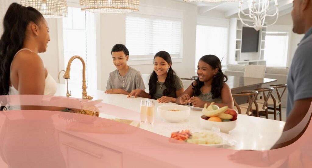 family sitting around table cutting fresh fruits