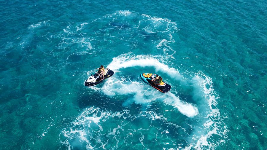 2 people riding jet skis on the blue ocean